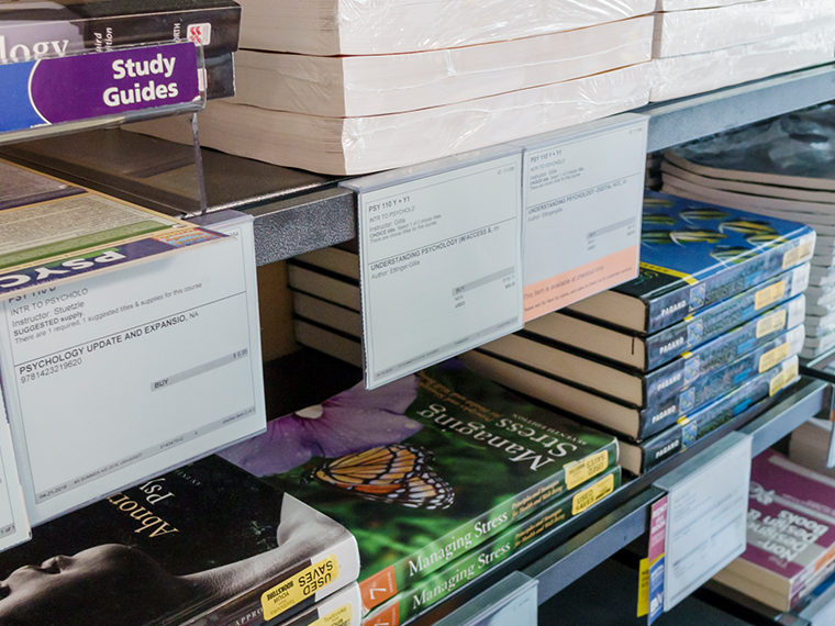 Stack of college textbooks on a shelf
