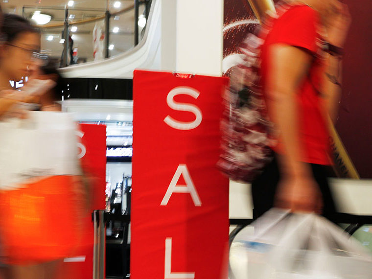 Sale signs at a mall with people walking