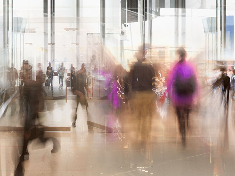 Blurred image of people walking through a building