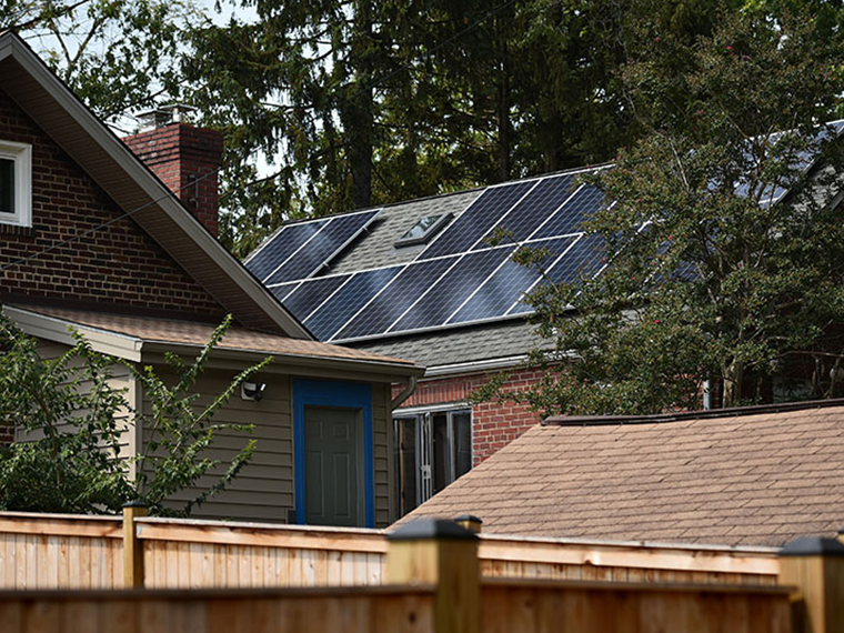 A brick home with solar panels on the roof