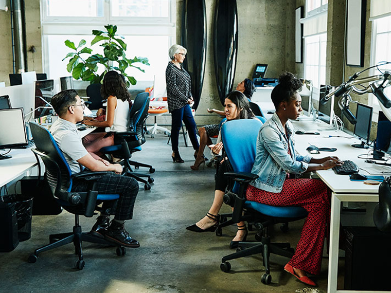 Six office workers seen talking and performing various tasks