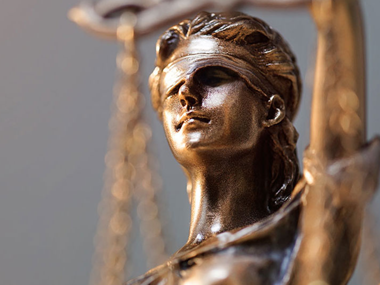 A close-up image of the bronze Lady Justice statue