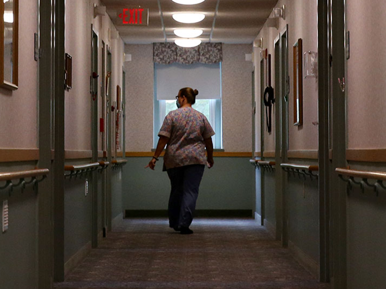 An image of a nurse walking down a hallway in a nursing home