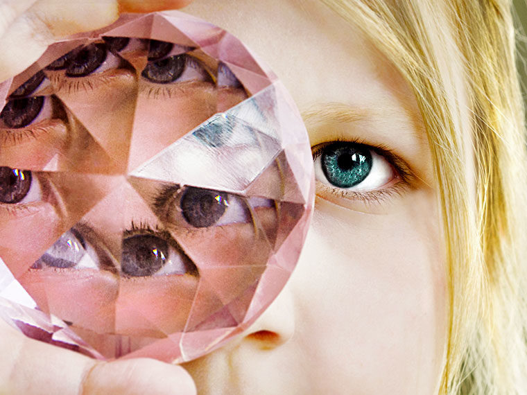 Person looking through a multifaceted gemstone