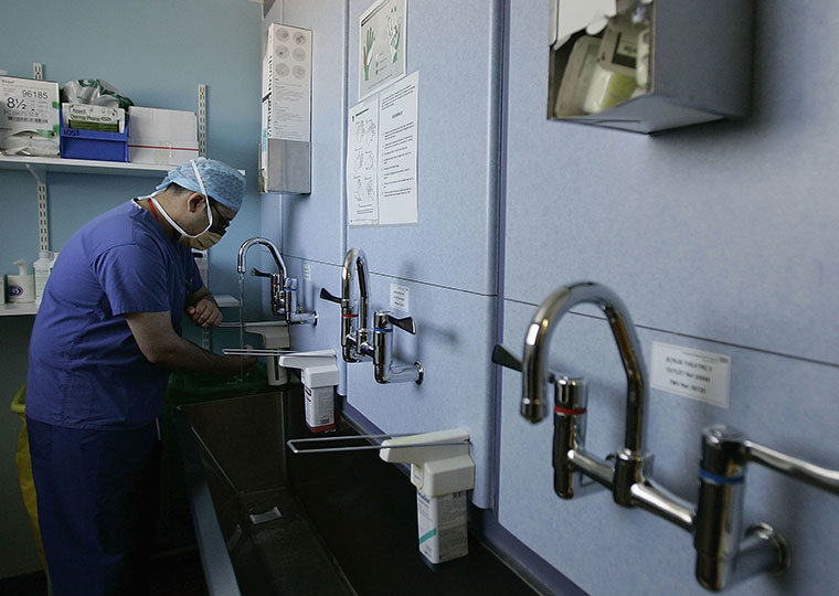 Surgeon thoroughly washes his hands at a sink