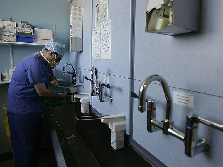 Surgeon thoroughly washes his hands at a sink