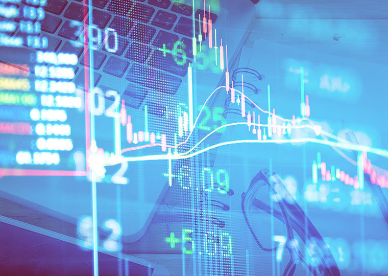 Composite image of stock charts overlaid on an image of a laptop