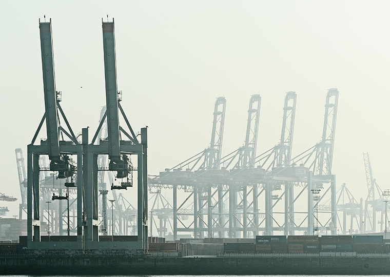 Rows of gantry cranes at a harbor on a hazy day