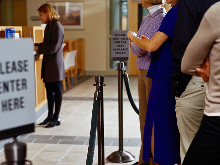 Queue of disgruntled people waiting in line for a bank teller