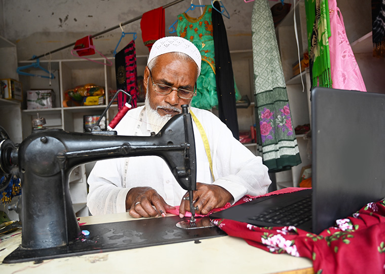 An Indian man works at a sewing machine
