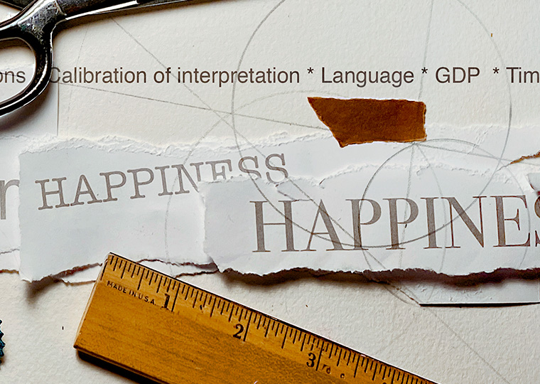An illustration featuring text that reads "happiness" and other items such as scissors and a ruler
