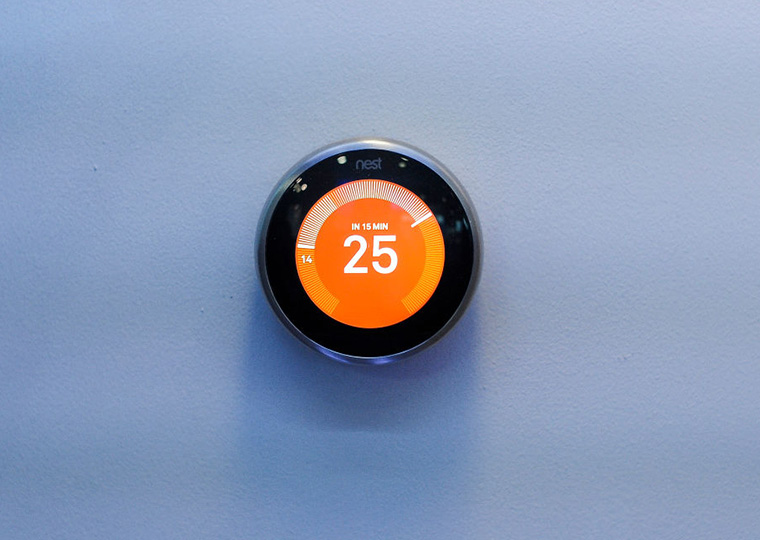 A nest thermostat on the wall reads 25 degrees