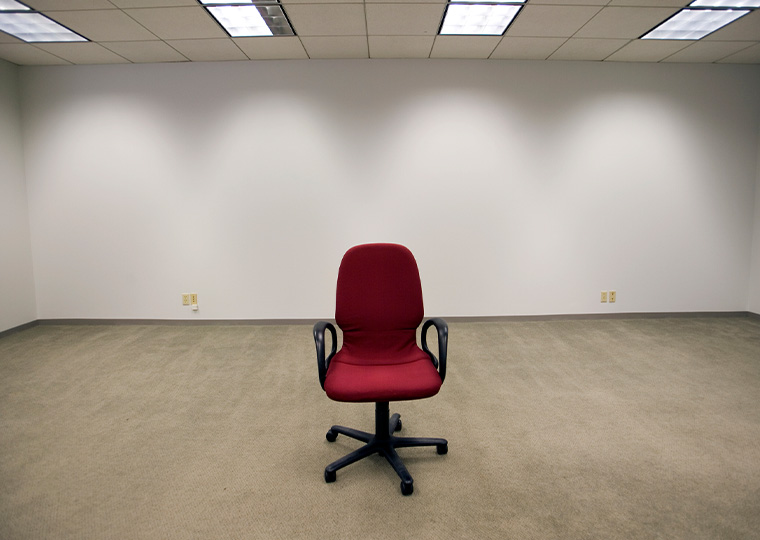 A lone red char in empty office.