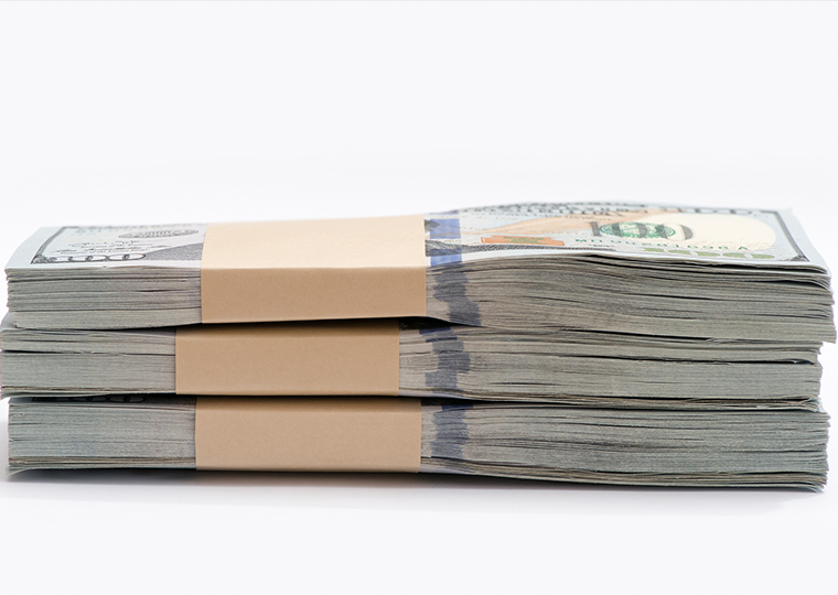 One stack of three wrapped groups of 100-dollar bills on a white background.