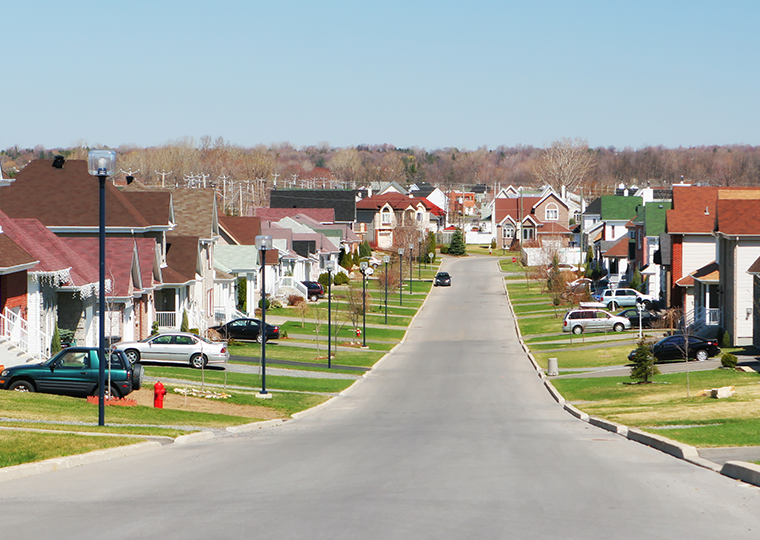A residential street with houses on each side of the street,