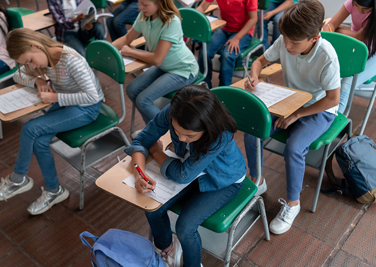 A classroom of middle school students taking a test at their desks.