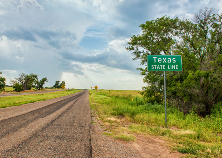 Texas state line sign next to historic Route 66 near the town of Texola, Oklahoma.