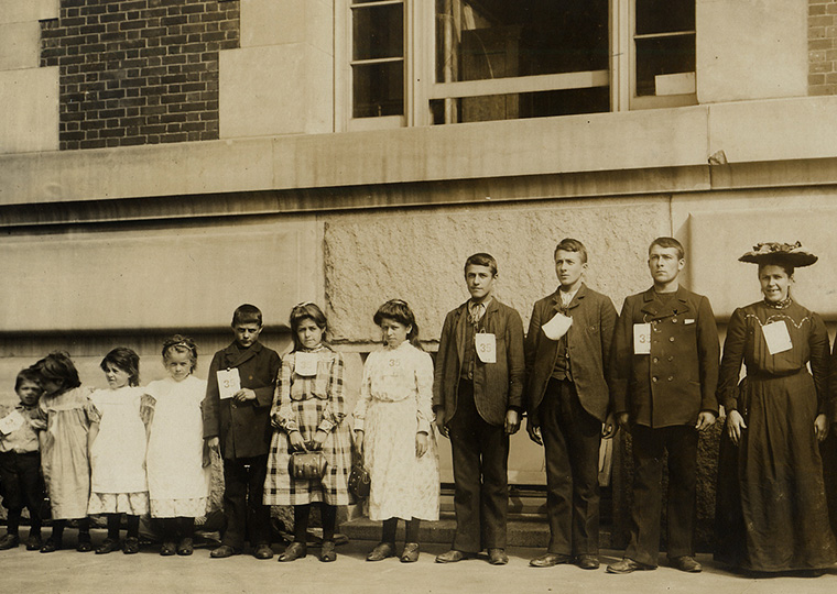 A line of 13 members of a family lined up to the mother at Ellis Island