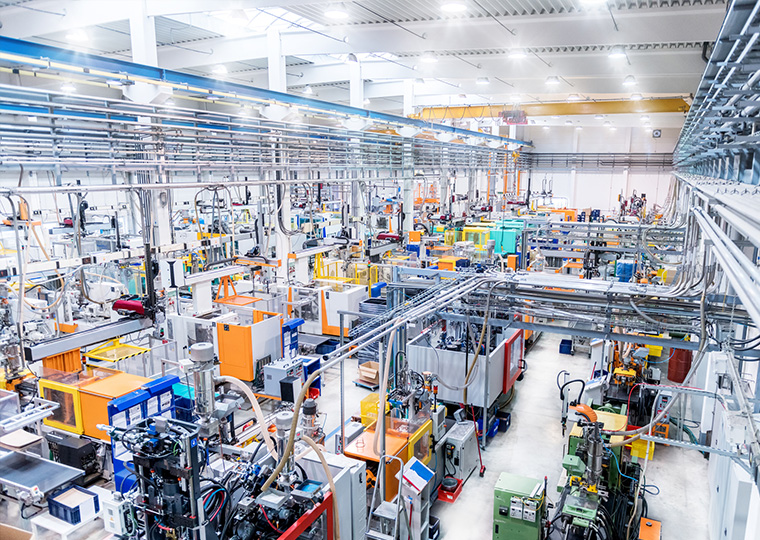 Horizontal color image of modern plastic factory with industrial machinery.