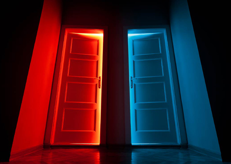 A red door slightly open on the left and a blue door slightly open on the right.