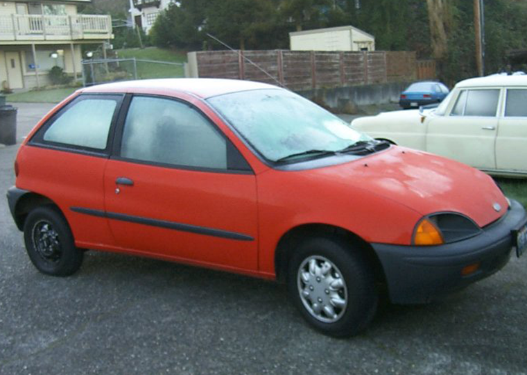 A red Geo Metro with fogged up windows.