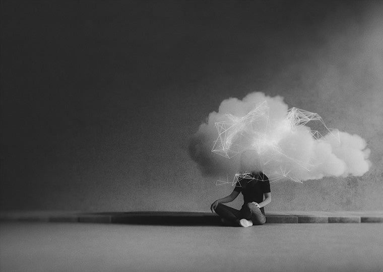 A black and white image of a teenager sitting on a floor with clouds covering their head.