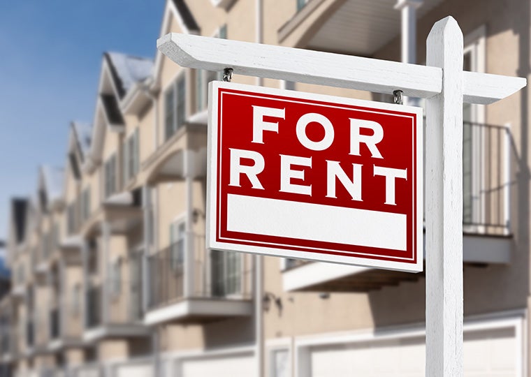 A for rent sign in front of a row of houses