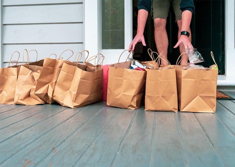 Man taking the grocery shopping left on the porch of the house.